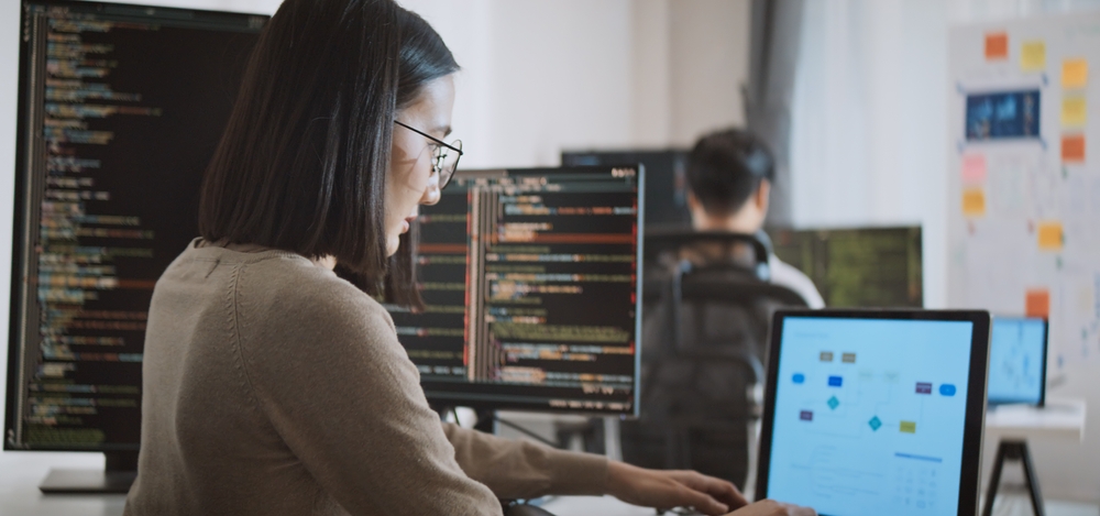 mulher asiática analisando dados em seu computador